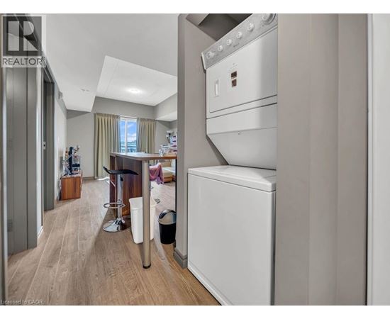 A modern kitchen with a white oven and a wooden floor.