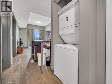 A modern kitchen with a white oven and a wooden floor.