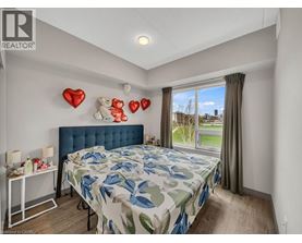 A bedroom with a blue headboard and a large bed with a leaf patterned comforter.