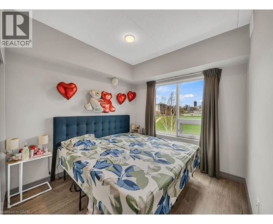 A bedroom with a blue headboard and a large bed with a leaf patterned comforter.