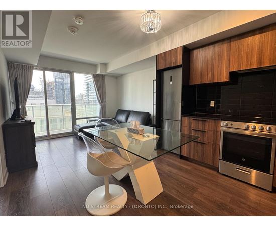 A modern kitchen with a glass table and two white chairs.
