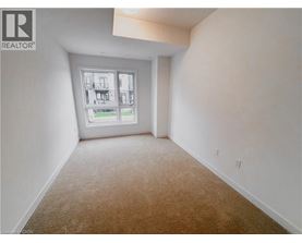 A room with a carpeted floor and a window showing a view of a building.