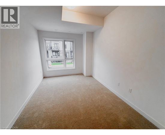 A room with a carpeted floor and a window showing a view of a building.