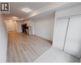 A spacious room with wooden flooring and white walls.