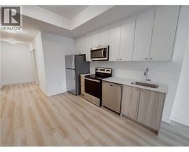 A kitchen with wooden floors and white walls.