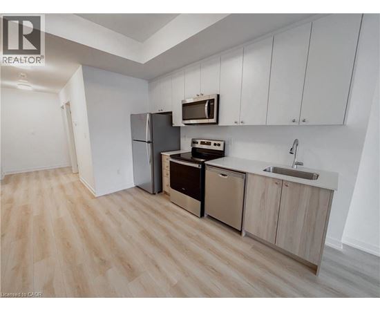 A kitchen with wooden floors and white walls.