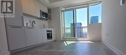 A kitchen with a microwave above the oven and a view of the city.