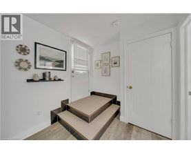 A hallway with a white door and a wall with pictures and decorations.