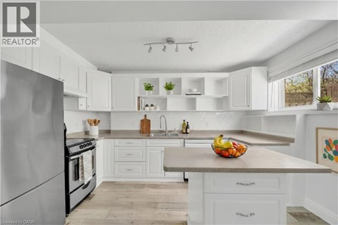 A modern kitchen with white cabinets and a stainless steel refrigerator.