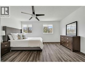 A bedroom with a bed, dresser, and ceiling fan.