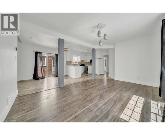A spacious living room with hardwood floors and a large window.