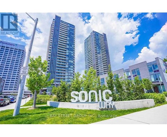 A real estate sign in front of a building with the words "SONIC WAY" on it.