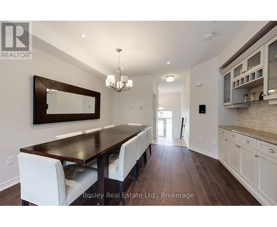 A dining room with a wooden table and white chairs.