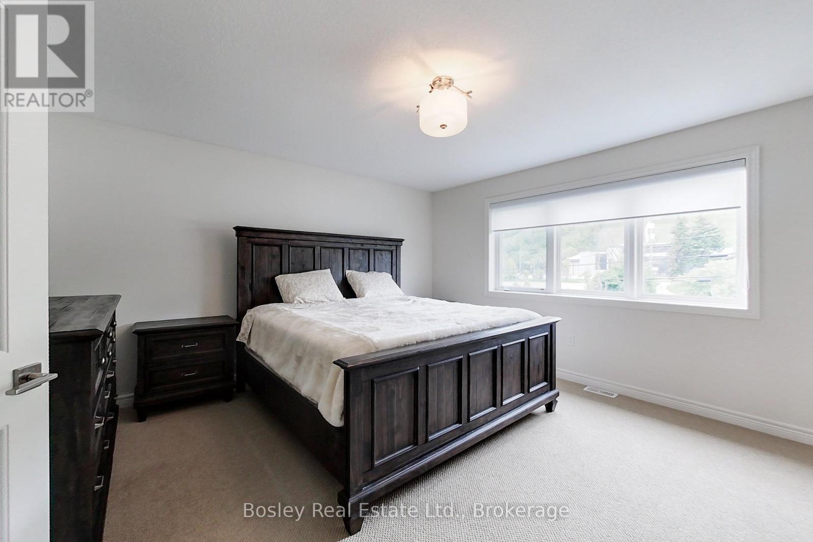 A bedroom with a large bed and a window.