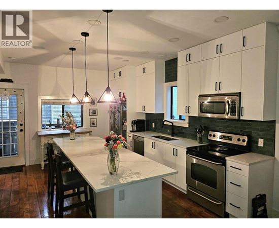 A modern kitchen with white cabinets and a central island.