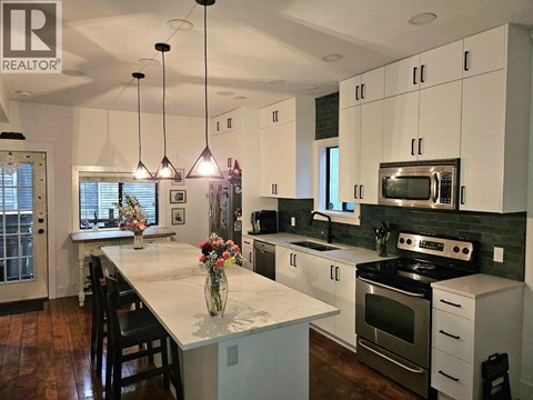 A modern kitchen with white cabinets and a central island.