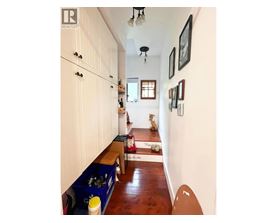 A long hallway with a bench and a few pictures on the wall.