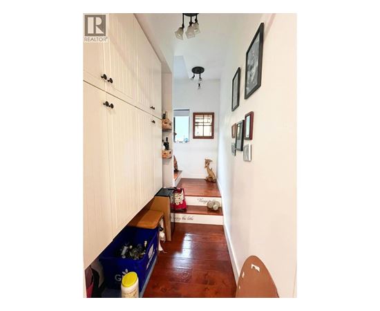 A long hallway with a bench and a few pictures on the wall.