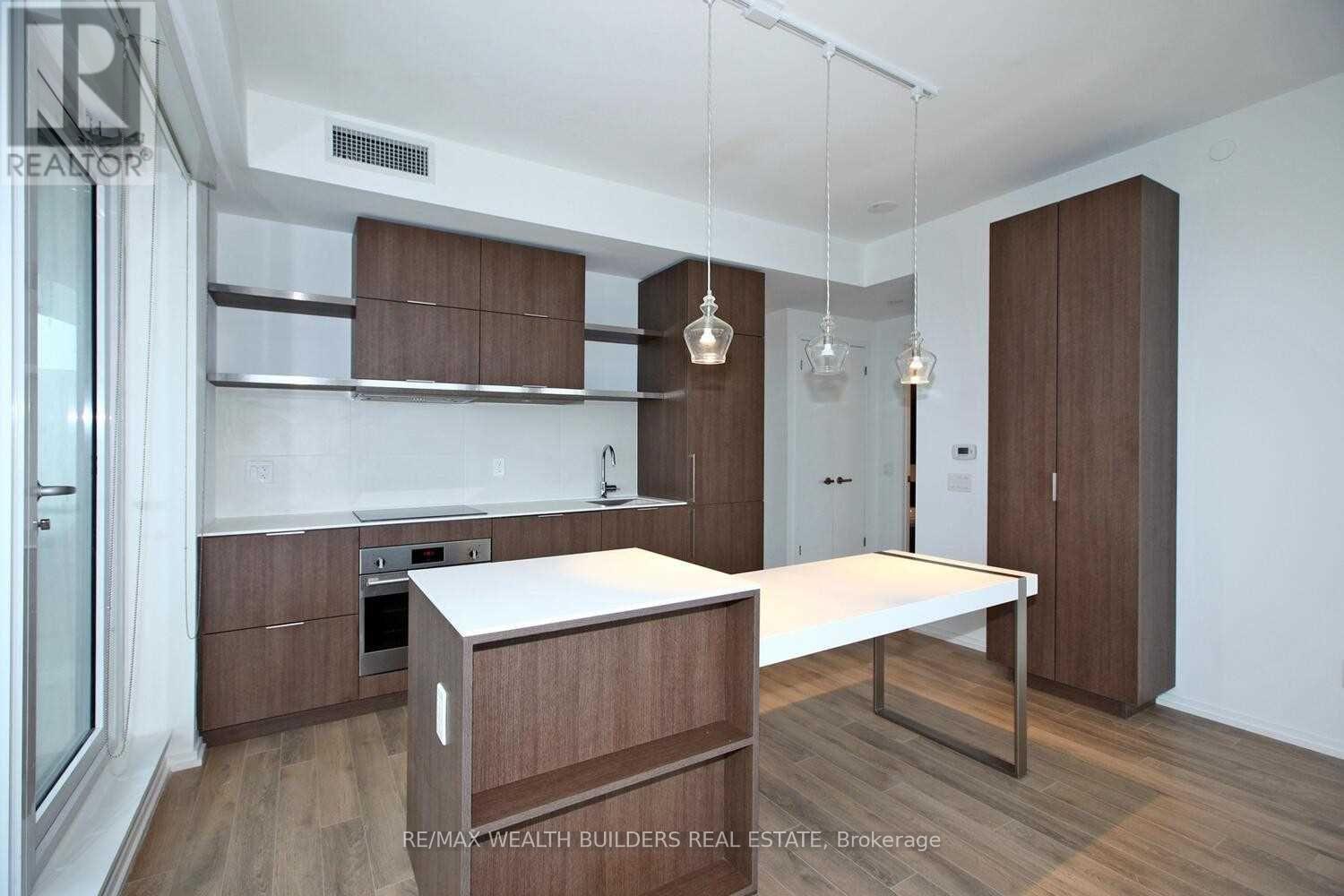 A modern kitchen with wooden cabinets and a white island.