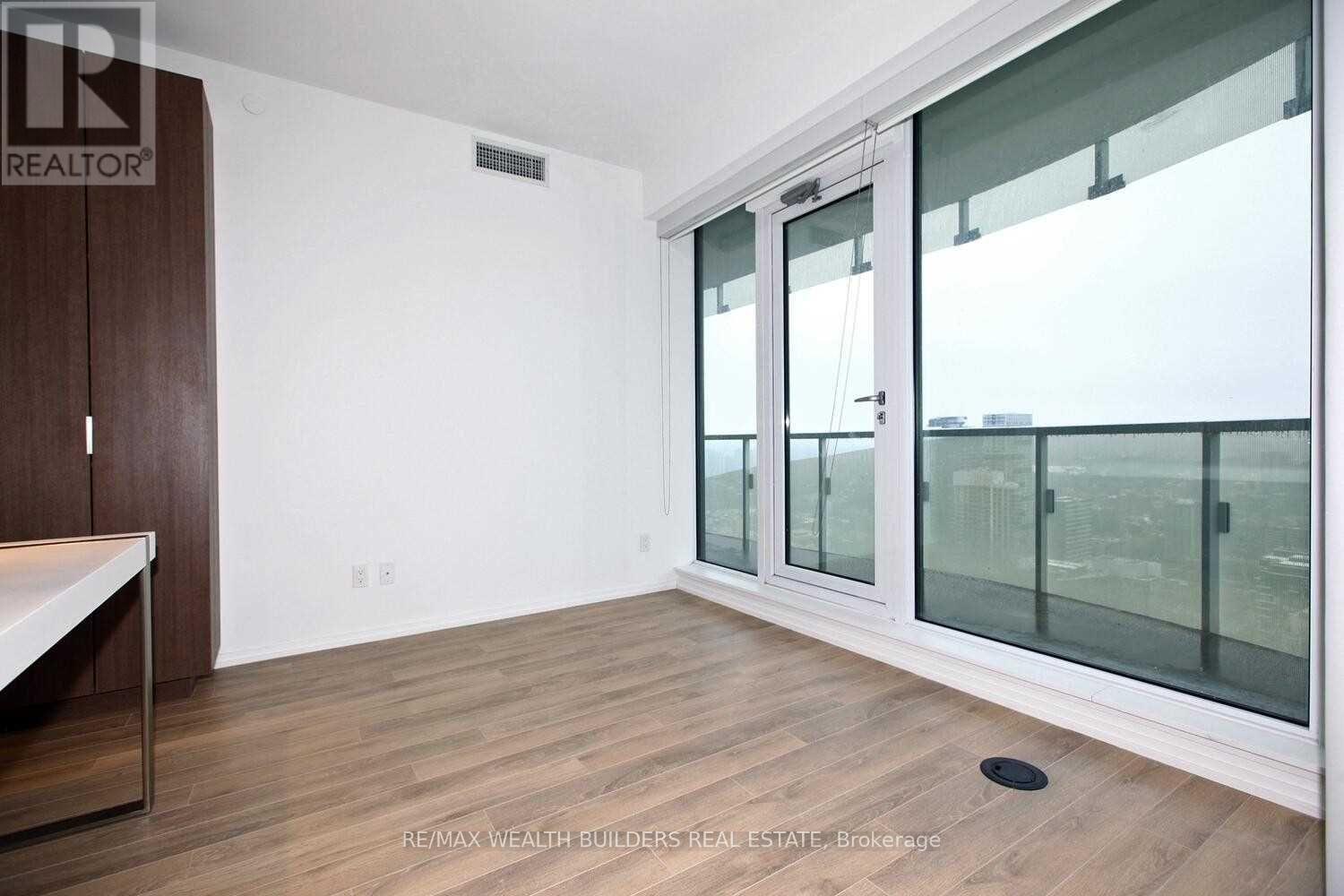 A room with a sliding glass door and a wooden floor.