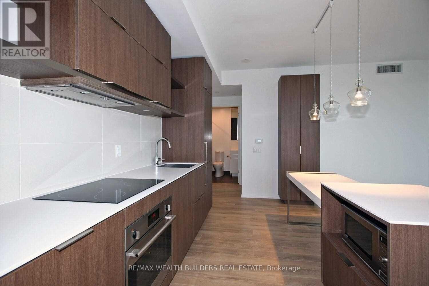 A modern kitchen with wooden cabinets and stainless steel appliances.