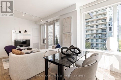 A modern living room with a glass table and a white sofa.
