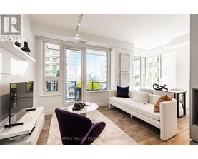 A living room with a purple chair and a white couch.