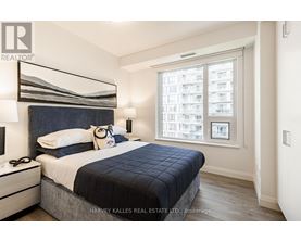A bedroom with a large bed and a window overlooking a cityscape.
