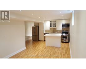 A kitchen area with a refrigerator, microwave, oven, and sink.
