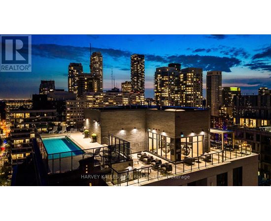 A cityscape at dusk with a pool and apartment building.