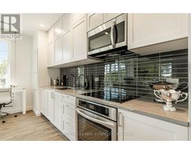 A modern kitchen with white cabinets and a glass backsplash.