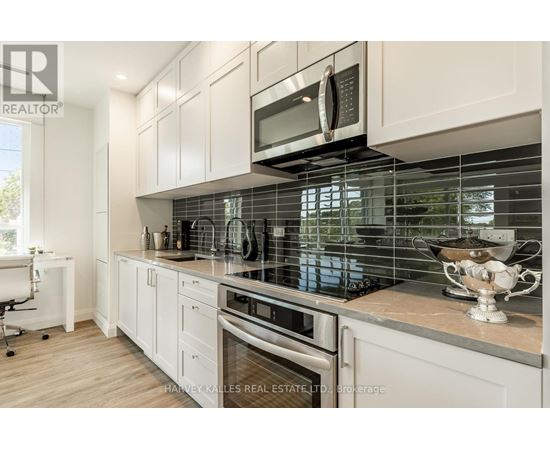 A modern kitchen with white cabinets and a glass backsplash.