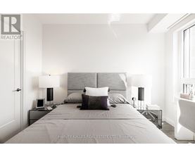 A bedroom with a large bed and two lamps.