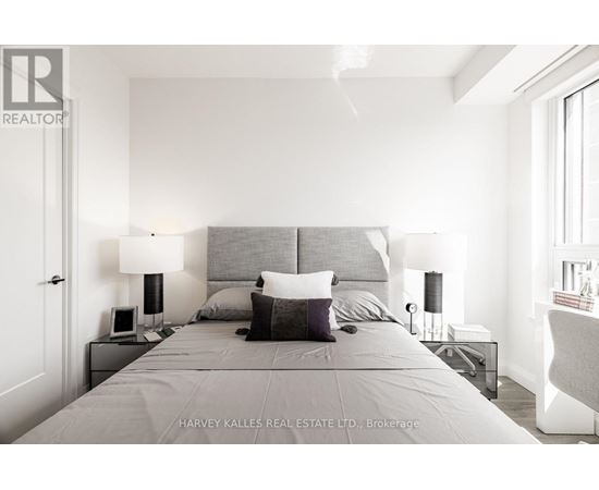 A bedroom with a large bed and two lamps.