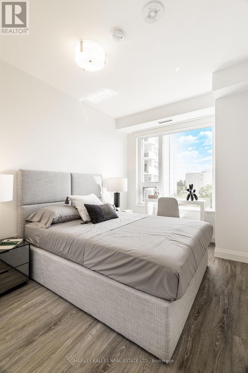 A bedroom with a large bed and a window overlooking a cityscape.