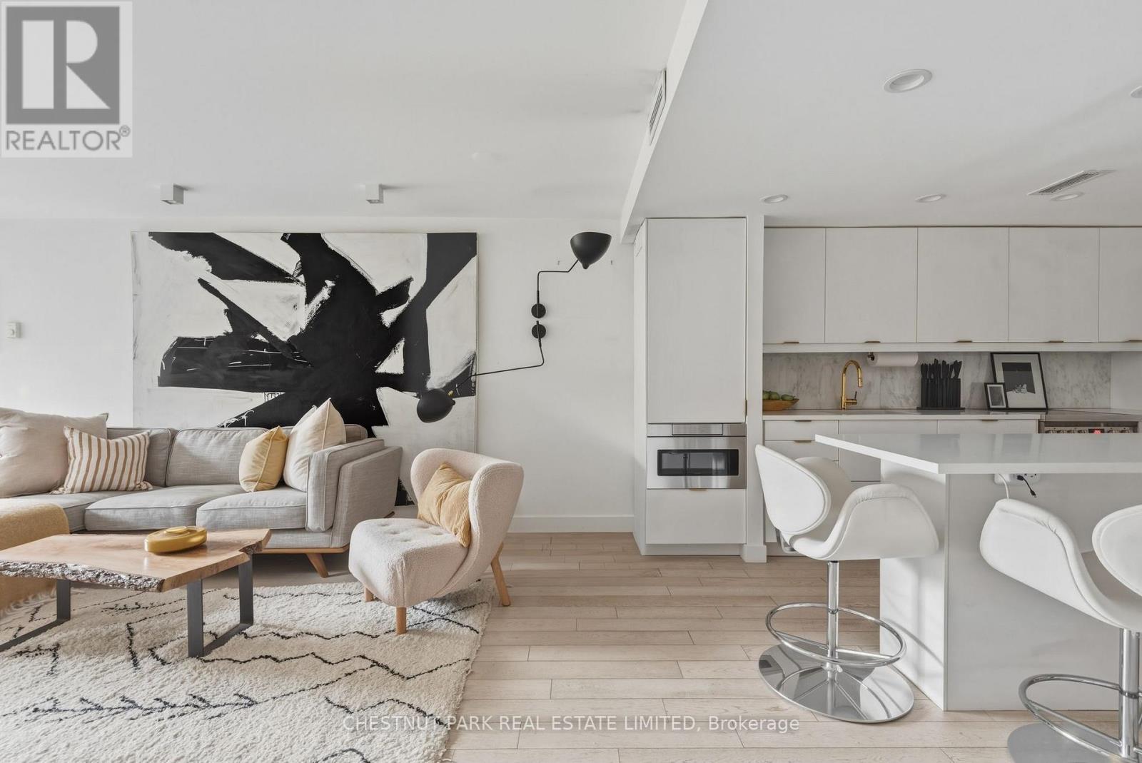 A modern living room with a large abstract painting on the wall.