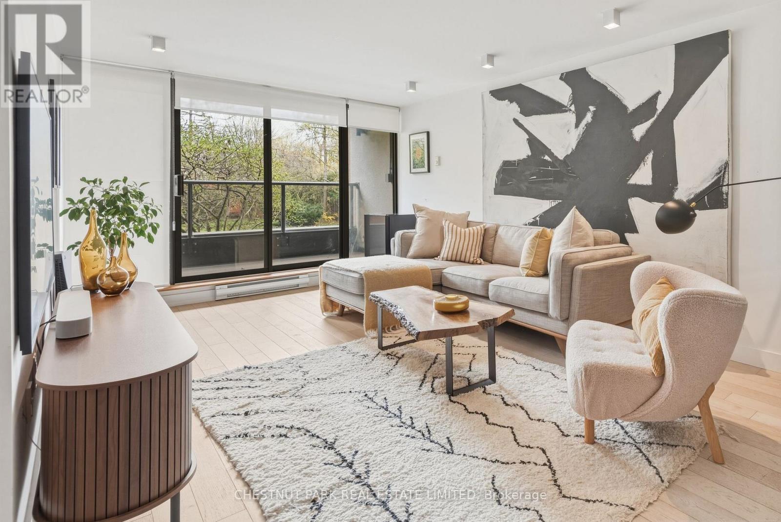 A living room with a large abstract painting on the wall.