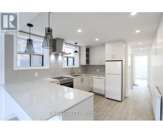 A modern kitchen with white appliances and cabinets.