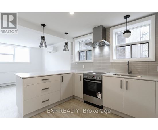A modern kitchen with white cabinets and a stainless steel oven.