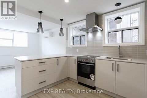 A modern kitchen with white cabinets and a stainless steel oven.