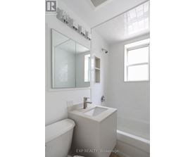 A white bathroom with a tub, sink, and mirror.