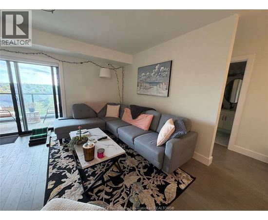 A living room with a grey couch and a coffee table in front of a window.