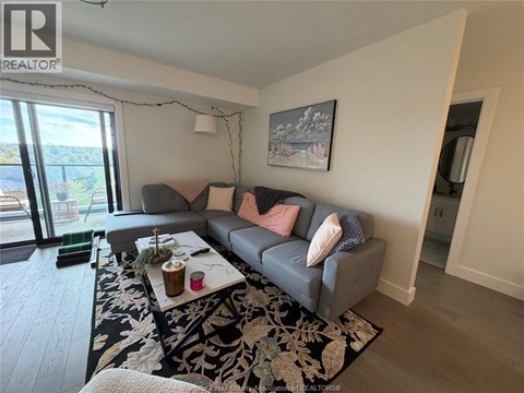 A living room with a grey couch and a coffee table in front of a window.