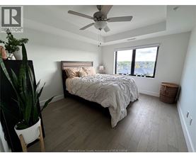 A bedroom with a bed, a plant, and a window.