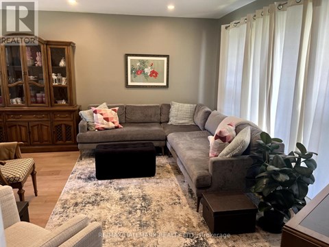 A living room with a grey couch and a wooden cabinet.