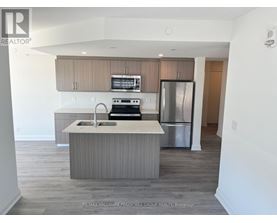 A kitchen with a sink, stove, and refrigerator.