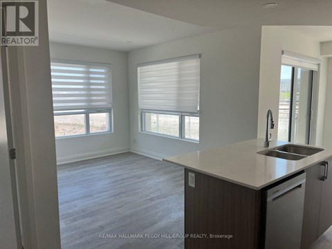 A kitchen with a sink and a window with blinds.