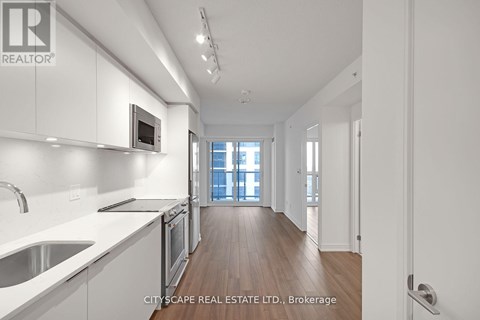 A modern kitchen with white cabinets and stainless steel appliances.