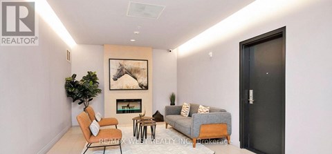 A living room with a fireplace and a painting on the wall.