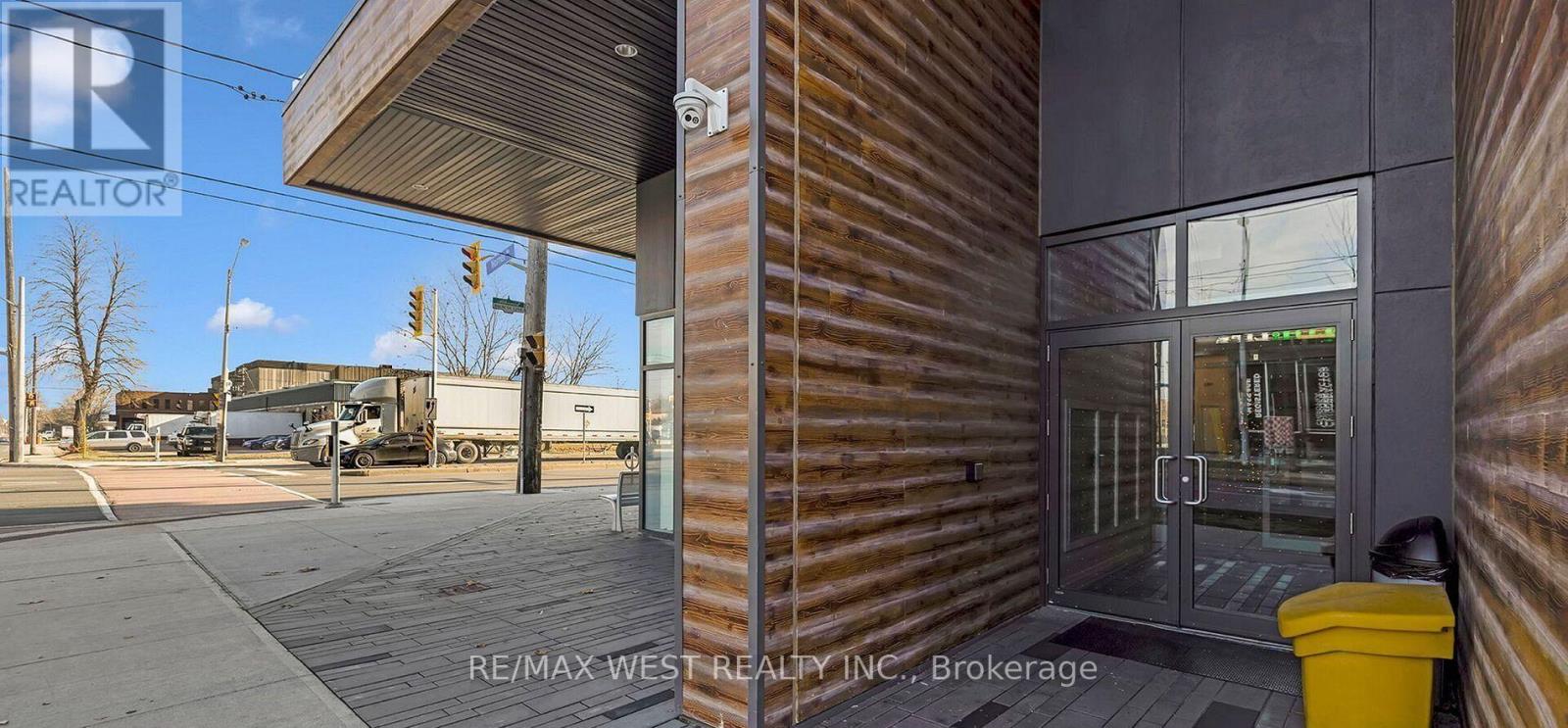 A RE/MAX West Realty Inc. brokerage office with a yellow trash can in front.